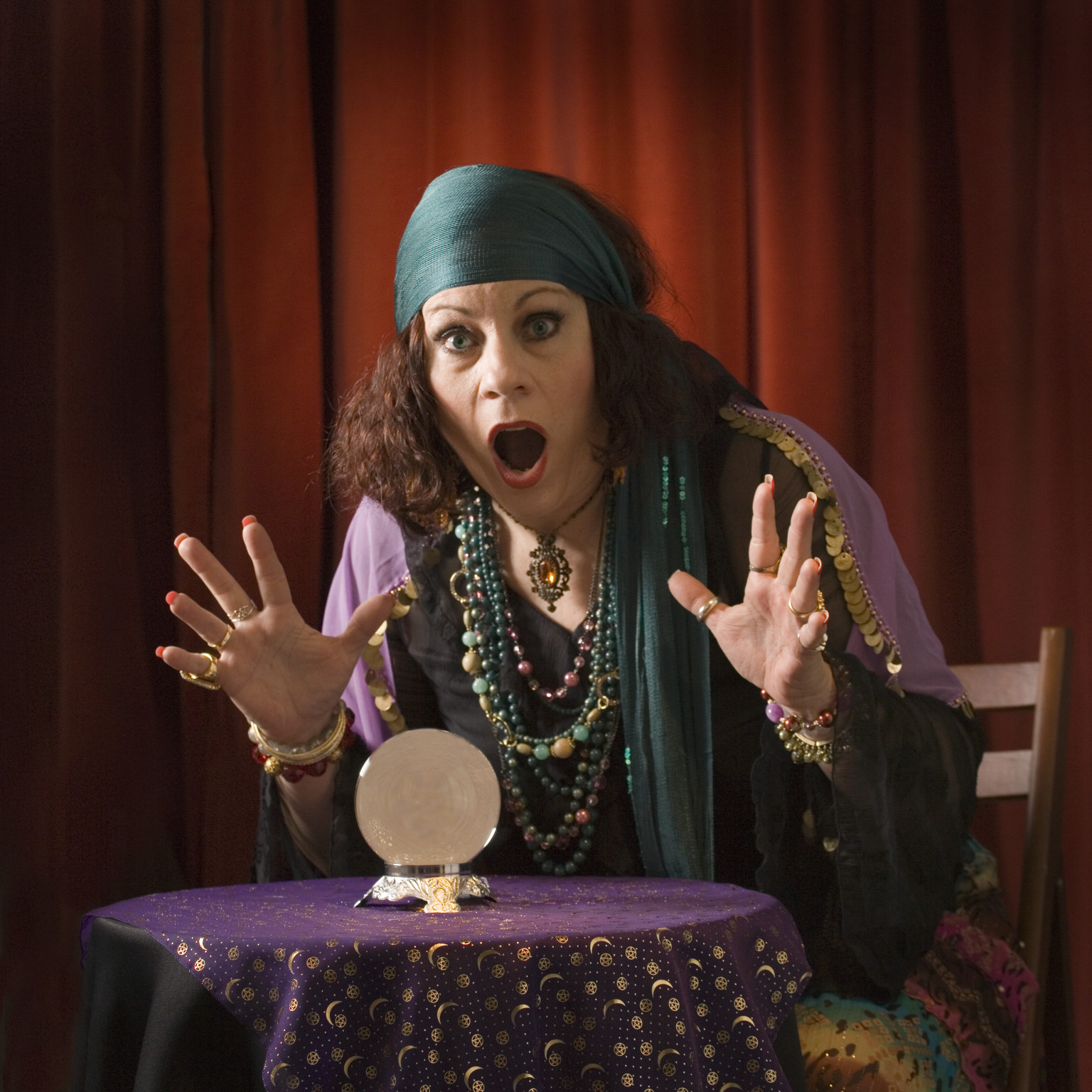 Female fortune teller with crystal ball, mouth open, portrait.